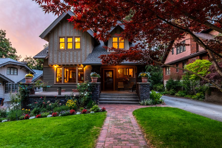 Beautiful home exterior at twilight with warm garden lighting
