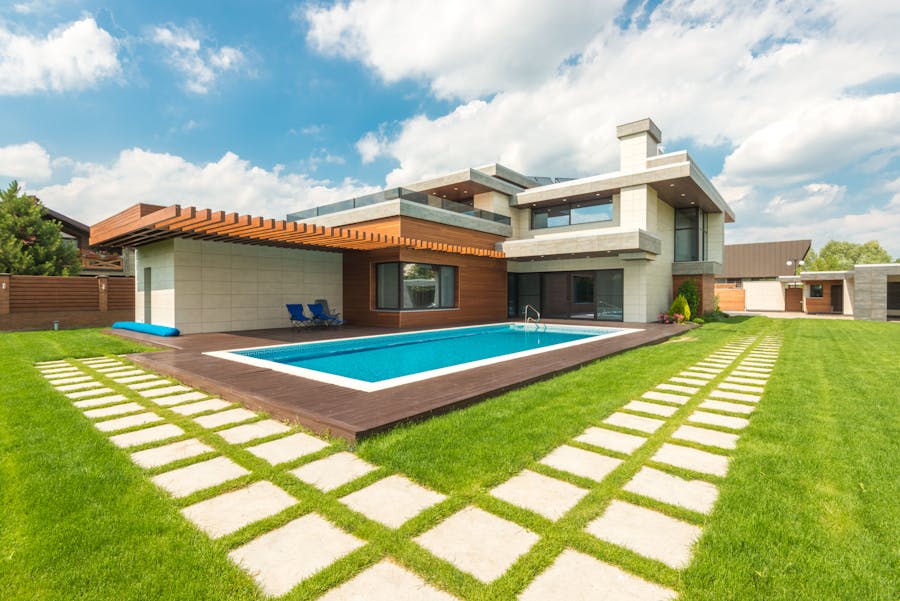 Modern home exterior with pristine pool and manicured lawn